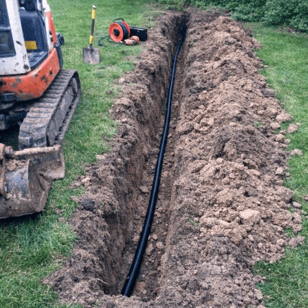 Kabelgraben entlang einer Einfahrt vor dem Verfüllen mit Sandbett